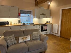 a living room with a couch and a kitchen at The Milking Parlour, Wolds Way Holiday Cottages, 1 bed cottage in Cottingham