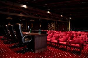 ein leeres Theater mit roten Stühlen und einem Rednerpult in der Unterkunft Aivazovsky Congress Hotel & Spa in Gjumri + 76 Fotos
