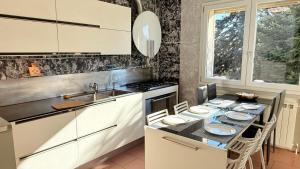 a kitchen with a table with chairs and a sink at Family 3-Bedroom Apartment near MXP & Lake Maggiore - Parking in Sesto Calende