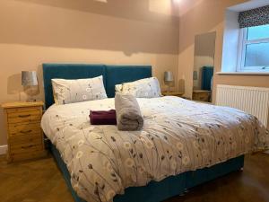 a bedroom with a bed with a blue headboard at The Milking Parlour, Wolds Way Holiday Cottages, 1 bed cottage in Cottingham
