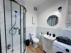 a bathroom with a shower and a toilet and a sink at Apartamenty przy Galerii in Kluczbork +29 photos