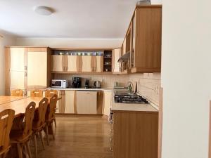 a kitchen with wooden cabinets and a table and chairs at Chata pod Radhoštěm in Trojanovice