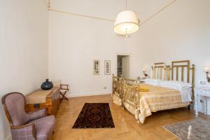 a bedroom with a bed and a chair at Palazzo De Giorgi B&B in Lecce