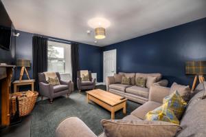 a living room with blue walls and a couch and chairs at Burnside, Dornoch in Dornoch