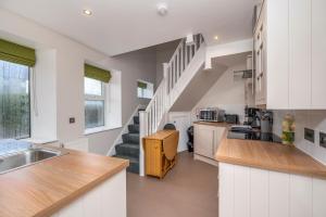a kitchen with white cabinets and a staircase at Burnside, Dornoch in Dornoch