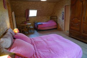 a living room with pink sheets on a couch at Plantes et sabots in Barriac-les-Bosquets +2 photos