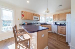 a kitchen with wooden cabinets and a black counter top at Dolphin's Song -Corolla, Villages at Ocean Hill, 350 Yds to Beach, Pets OK, Hot Tub, Community Pools in Corolla