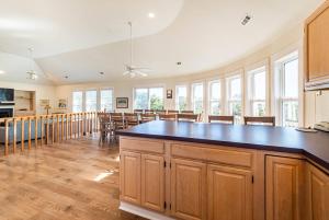 a large kitchen and dining room with a large island at Dolphin's Song -Corolla, Villages at Ocean Hill, 350 Yds to Beach, Pets OK, Hot Tub, Community Pools in Corolla +50 photos
