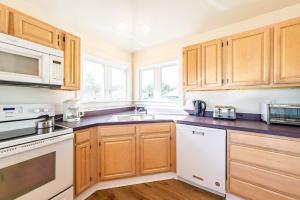 a kitchen with wooden cabinets and a sink at Dolphin's Song -Corolla, Villages at Ocean Hill, 350 Yds to Beach, Pets OK, Hot Tub, Community Pools in Corolla