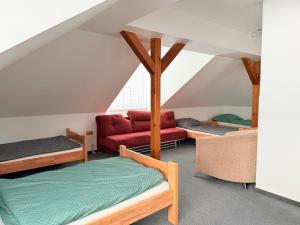 a attic room with beds and a red couch at Chata pod Radhoštěm in Trojanovice +20 photos