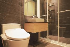 a bathroom with a toilet and a sink and a shower at Moving Star Hotel in Nan-tzu-ts'un