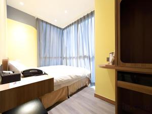 a hotel room with a bed and a television at Moving Star Hotel in Nan-tzu-ts'un