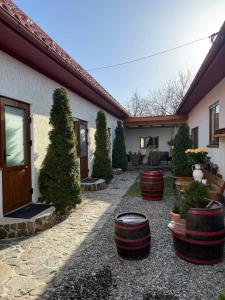 a courtyard with a house with trees and barrels at KOMFORT in Berehove