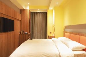 a hotel room with a bed and a flat screen tv at Moving Star Hotel in Nan-tzu-ts'un