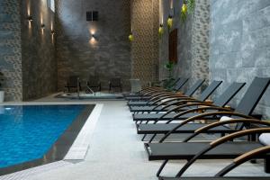eine Stuhlreihe neben einem Schwimmbecken in der Unterkunft Aivazovsky Congress Hotel & Spa in Gjumri