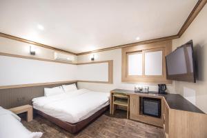 a hotel room with a bed and a tv at Lien Hotel Haeundae in Busan