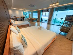 a bedroom with two beds and a living room at Laguna Khaokho in Khao Kho
