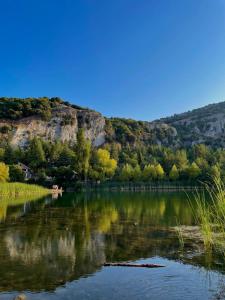 a lake with trees and a mountain in the background at Antares in Isnello