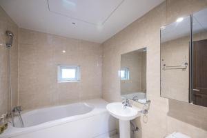 a bathroom with a tub and a sink and a toilet at Lien Hotel Haeundae in Busan +42 photos