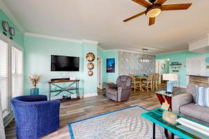 a living room with blue walls and a flat screen tv at Paradise Shores 200 in Mexico Beach