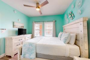 a bedroom with a white bed and a ceiling fan at Paradise Shores 200 in Mexico Beach