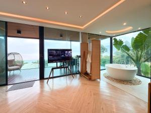 a large bathroom with a tub and a television in it at Laguna Khaokho in Khao Kho