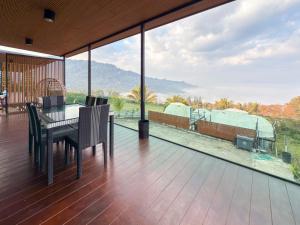 a patio with a table and chairs on a deck at Laguna Khaokho in Khao Kho
