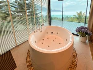 a bath tub in a room with a large window at Laguna Khaokho in Khao Kho +80 photos