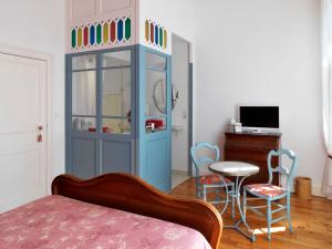 a bedroom with a blue cabinet with chairs and a table at Villa Lea in Toulouse