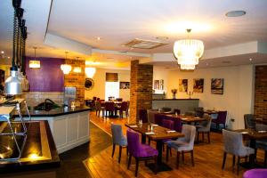 a restaurant with tables and chairs and a bar at Ty Newydd Country Hotel in Hirwaun