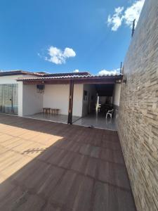 a large outdoor deck with a brick wall at Casa com piscina in Petrolina