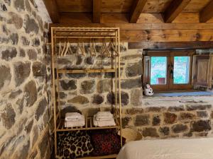a room with a bed in a stone wall at Cabaña Los Picones in Pisueña