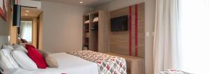 a bedroom with a bed and a room with a closet at Laghetto Stilo Borges - Apto 403B in Gramado