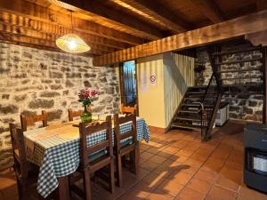 a dining room with a table and chairs and a staircase at Cabaña Los Picones in Pisueña