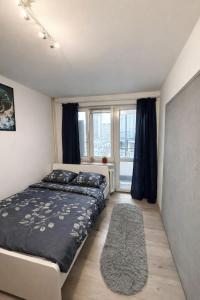 a bedroom with a bed and a large window at Chmielna Residence in Warsaw