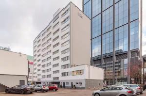 a large building with cars parked in a parking lot at Chmielna Residence in Warsaw