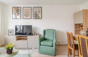 a living room with a green chair and a television at Chmielna Residence in Warsaw