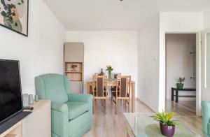 a living room with a blue chair and a table at Chmielna Residence in Warsaw