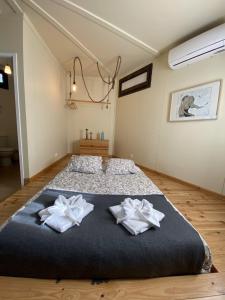 a bedroom with a large bed with two towels at YMCA Camp Alambre in Azeitao