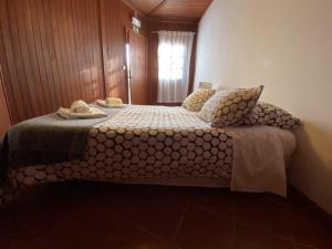 a bedroom with a bed with pillows and towels on it at YMCA Camp Alambre in Azeitao