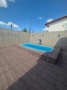 a swimming pool in a brick wall with a blue tub at Casa com piscina in Petrolina