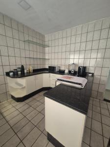 a kitchen with white cabinets and a black counter top at Casa com piscina in Petrolina