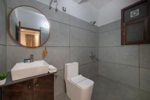 a bathroom with a sink and a toilet and a mirror at Whispering Woods Homestay Kasauli !! in Kasauli +11 photos