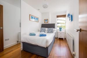 a bedroom with a bed with blue pillows on it at Castle Lanes - Minutes from Poole Quay, Poole Town Location in Poole