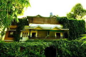 a house with ivy growing on the side of it at Clement homes in Kalpetta