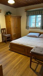 a bedroom with a large bed and a chair at Kovárna in Nová Paka