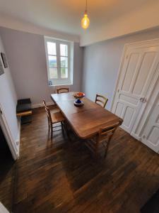 a dining room with a wooden table and chairs at La Cigalienne in Treignac