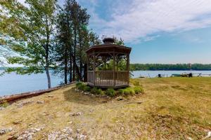 a gazebo sitting on top of a field near the water at Garden Island's Pine in Charlotte