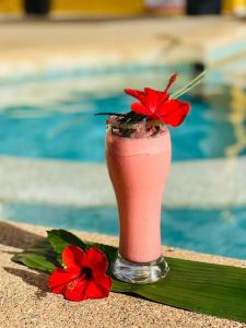 a drink with a red flower in a glass at La Brise de Ngaparou in Ngaparou