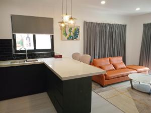a kitchen with a counter and a living room with a couch at Hibiscus Suites And Residences in Nadi
